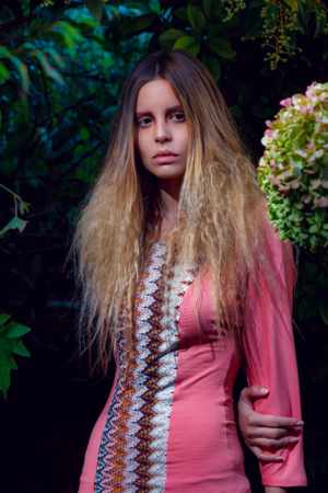 modelo en un bosque al atardecer con vestido rosado